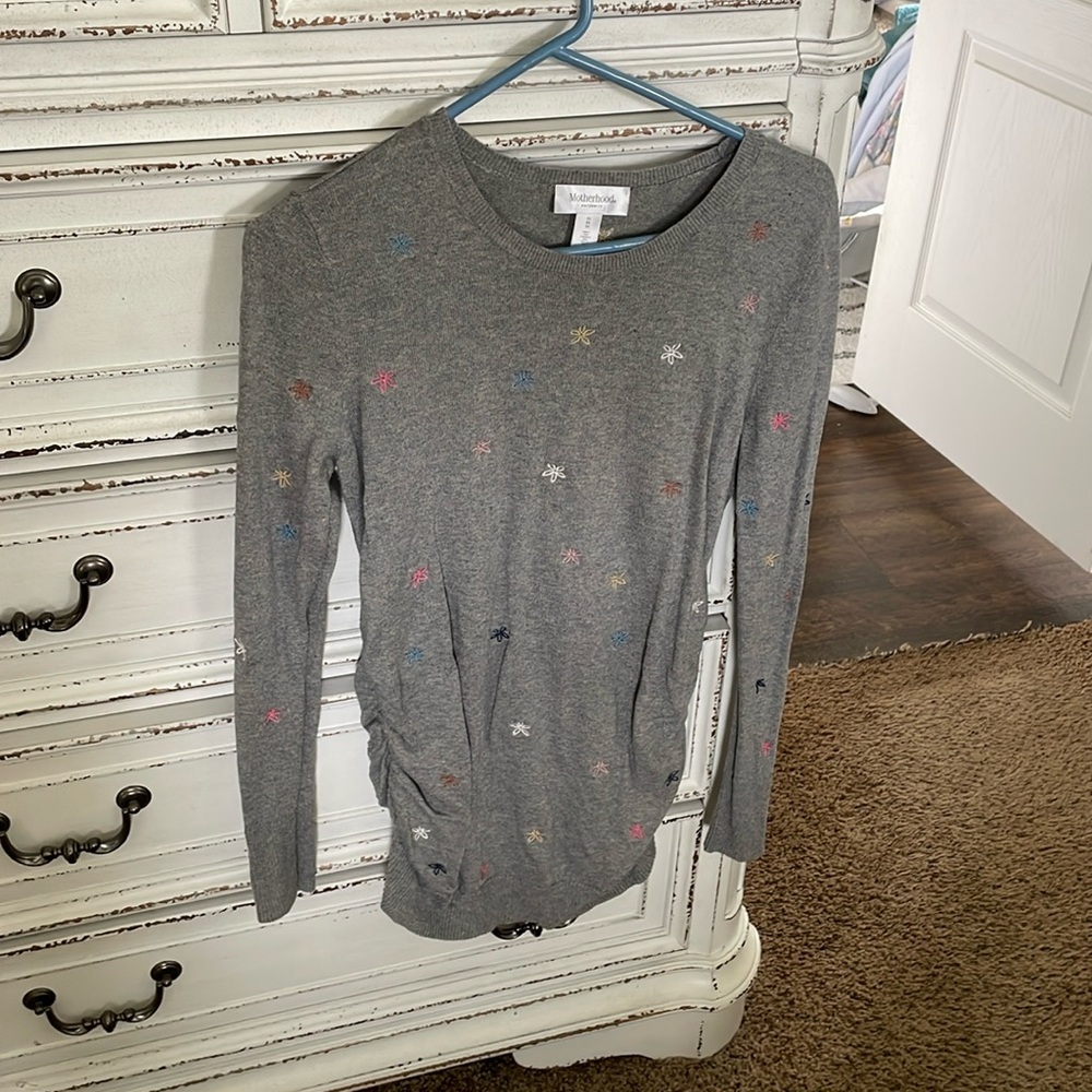 Motherhood maternity long sleeve sweater with flowers embroidered on it.